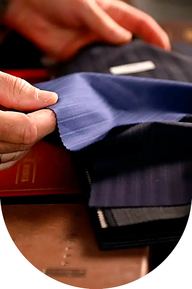 Manos tocando tejidos de alta calidad seleccionados por Trajes Yuste